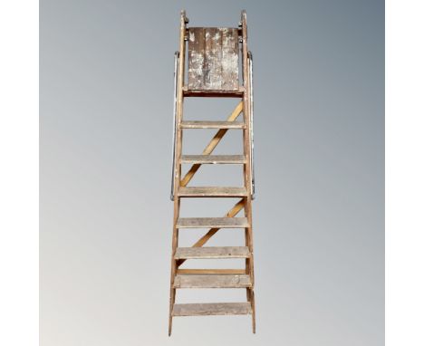 A folding wooden seven tread step with metal hand rails 