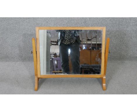 A Herbert Gibbs oak swing mirror, stamped to underside. H.52 W.64 D.25CM 