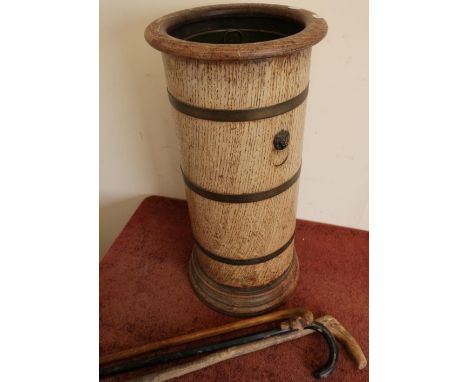 Brass bound oak stick stand with three sticks including a dog style walking stick with glass eyes 