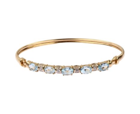 A modern 9ct gold blue topaz and cubic zirconia torque bangle, band width 5.6mm, internal circumference 18cm, 7.5gNo damage o