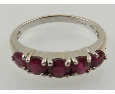 A 9 carat white gold and ruby ring, set five round cut rubies.