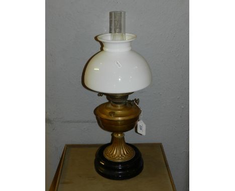 A Victorian style table lamp, having opaque white glass shade, shaped brass base set on a circular black base. H.58cm 