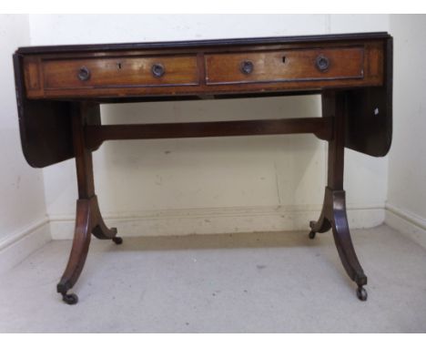 A Regency mahogany sofa table, the top having a reeded edge, two in-line drawers with brass ring handles on pressed backplate