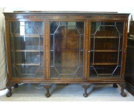 A 1920s mahogany display cabinet, having a low upstand and a shelf top with a rope carved and Vitruvian scrolled border, over