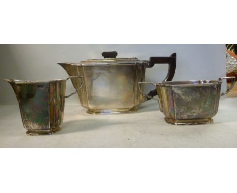 An Art Deco design three piece silver tea set of panelled form with double-incurved corners  comprising a teapot with Bakelit