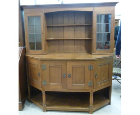 A Liberty & Co Arts & Crafts light oak dresser, the tongued and grooved planked back superstructure having a level, moulded c
