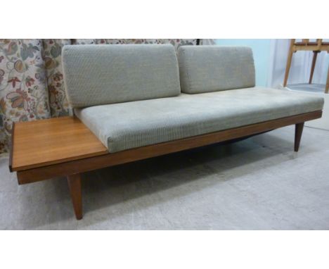 A 1960s Ekornes Svane teak and afrormosia framed sofa/daybed, having a twin cushion back and seat with an offset shelf, uphol