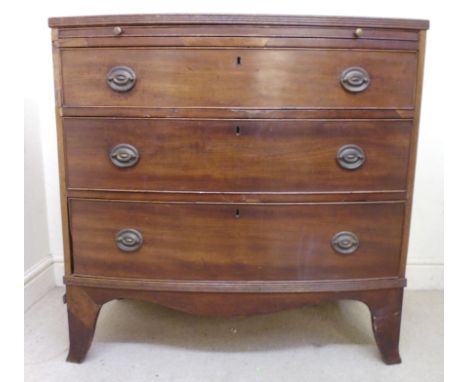 An early 19thC mahogany bow front dressing chest, having a brushing slide, over three graduated long drawers with curved hand