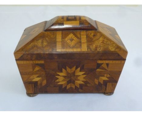 A shaped rectangular tea caddy inlaid with different woods depicting flowers and geometric forms on four bun feet