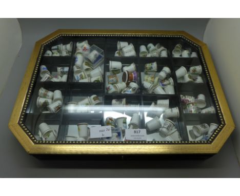 A display case with 93 ceramic thimbles **PLEASE NOTE THIS LOT IS NOT ELIGIBLE FOR POSTING AND PACKING** 