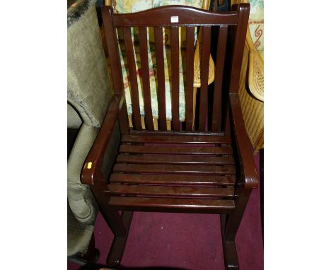 A stained teak slatted garden rocking elbow chair, width 62cm