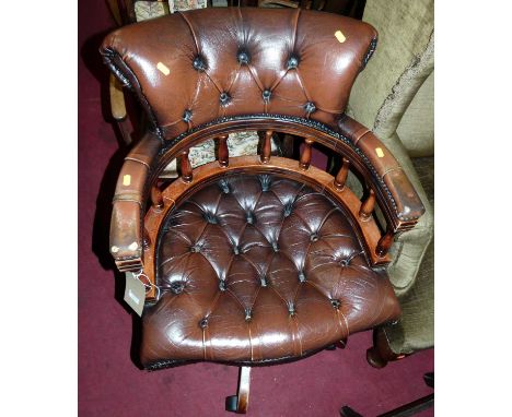 A contemporary mahogany tan leather buttoned and studded tub swivel desk chair, on roller castors, width 61.5cm