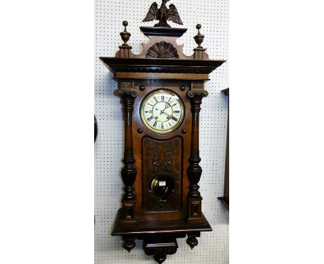 A large circa 1900 figured walnut Vienna drop trunk wall clock, with eagle surmount, glazed and floral relief carved trunk do