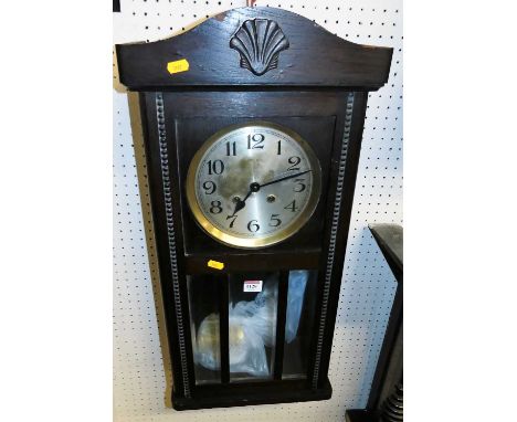 A 1920s oak drop trunk wall clock with pendulum, height 72cm