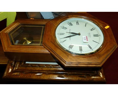 A contemporary oak drop trunk wall clock