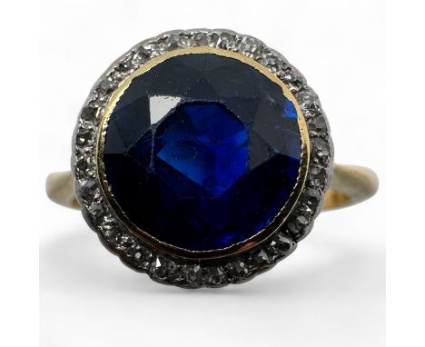 A sapphire and diamond dress ring, by Boodle and Dunthorne.  Stamped "18ct & Plat". Set with a round mixed cut sapphire, appr