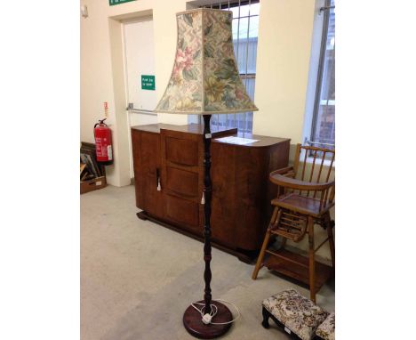 A dark wood standard lamp.