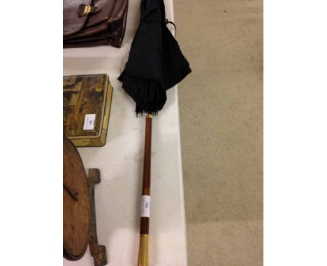 A vintage umbrella. Early 20th century with stitched leather handle, and brass finial & collar.