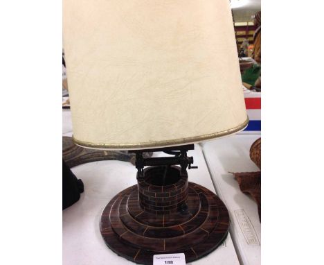 An Art Deco Cocobolo wood carved table lamp in the shape of a well.