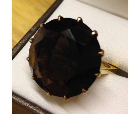 A very large smokey quartz stone set in an unusual square 9ct gold shank, size K