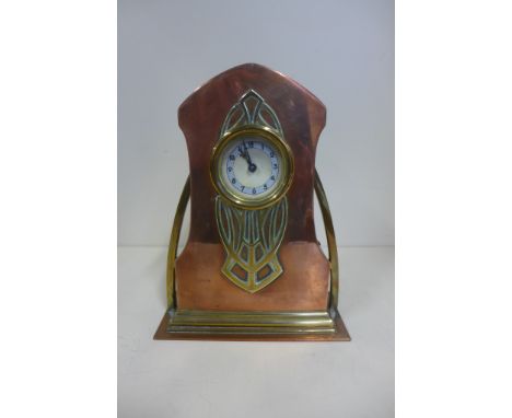 A brass and copper Art Nouveau mantle clock, 21cm tall, with replacement battery movement but with original part movement 