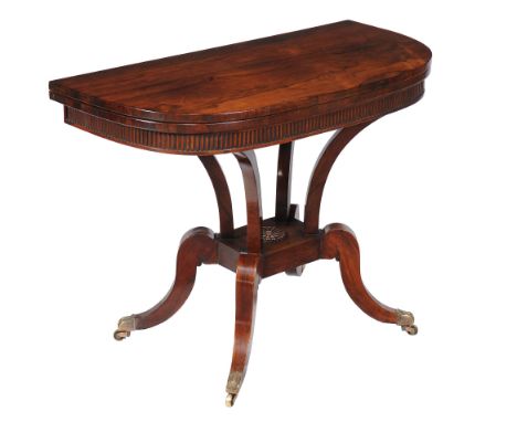 Ω A Regency rosewood card table , circa 1820, the folding D-shaped top enclosing a baize playing surface, above four supports