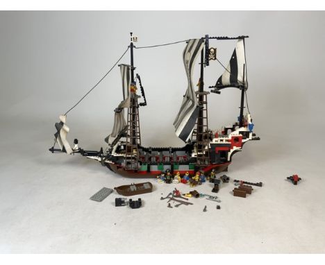 A Lego 6286 Skulls Eye Schooner toy set from 1993. Compass, map, figurines and props present.