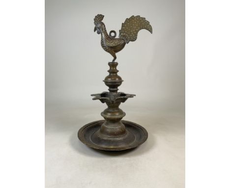 A late 19th early 20th century Indian Deccan brass oil lamp with cockerel finial and seven spouted reserve on knopped column 