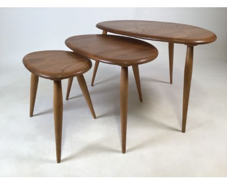 A Ercol nest of three light elm Pebble tables. Largest 64cm(w) 40cm(h) Label to base is smallest