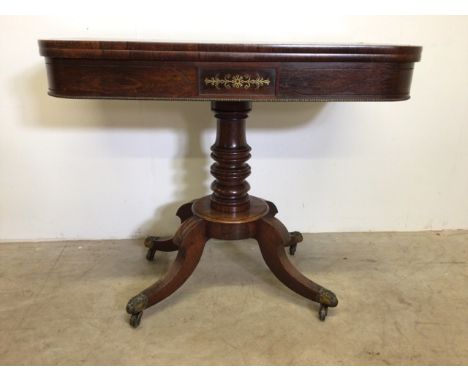 A rosewood twist top card table with brass inlay on a turned base with brass castors and feet.  W:92cm x D:46cm x H:75cm.   E