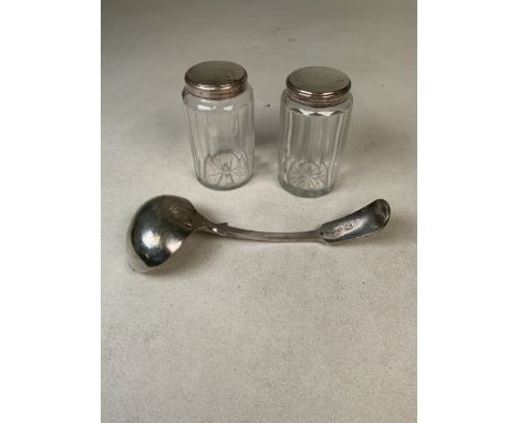 A white metal soup ladle together with a pair of white metal topped dressing table jars. 