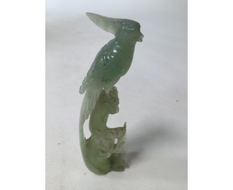 A finely carved jade statue of a bird amongst foliage. H:19cm