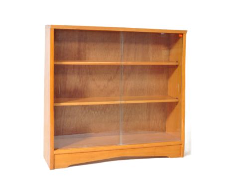 A mid 20th Century retro vintage teak wood bookcase. Of rectangular form with full length twin glazed doors with three shelve
