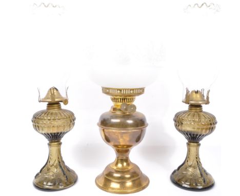  A pair of 19th century glass oil lamps with clear glass funnels. Together with another brass oil lamp having an etched globu