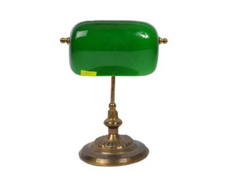 An early 20th century circa. 1920's bankers lamp having green glass shade over a brass base with gadrooned stepped circular f