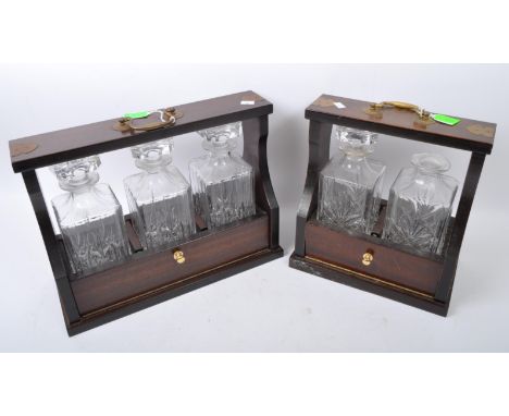 A pair of late 20th century Victorian decanter tantalus's. Each having cut glass decanters in mahogany brass bound frames. Me