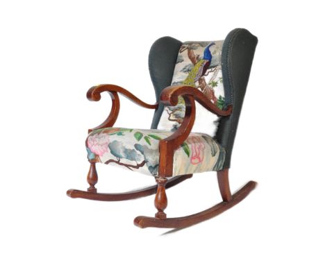 A 19th Century Victorian mahogany&nbsp;Biedermeier wing back rocking armchair. Having upholstered peacock tapestry decoration
