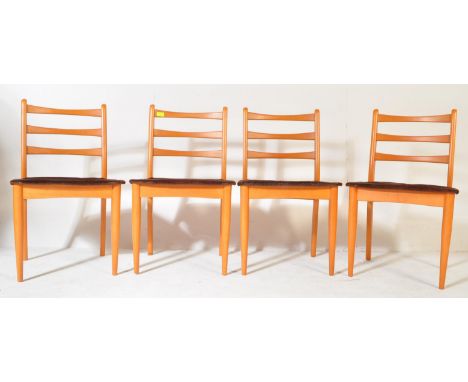 A set of four retro vintage mid 20th century teak Danish inspired dining chairs having a ladder back on padded seats raised o