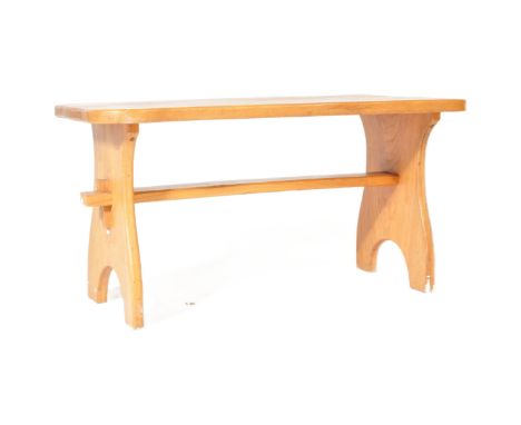 A vintage 20th century pine country style occasional coffee table having a curved top over shaped supports with central stret