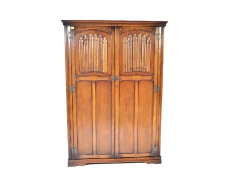 Old Charm&nbsp; - A vintage 20th century oak Jacobean Revival Old Charm double wardrobe having linen fold decoration to each 