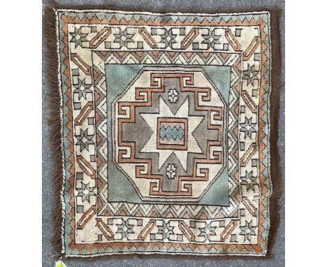 A 20th century Persian Islamic prayer carpet rug of squared shape having geometric stylised patterns throughout in orange, be