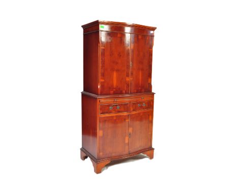 A 20th Century Regency Revival manner yew and mahogany veneer cocktail drinks cabinet having a double door cabinet top with s