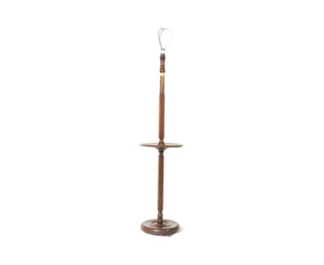 An early 20th century circa. 1920's turned mahogany floor standing standard lamp with circular shelf upon a circular raised o