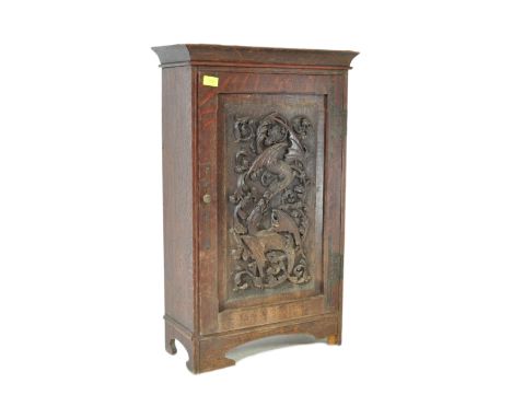 A 19th century Victorian era carved mahogany cabinet. The cabinet having single door with panel to front carved with foliates