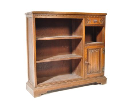 A 20th century Jacobean Revival oak Wood Bros Old Charm open front bookcase. The cabinet having a straight top over a shelved