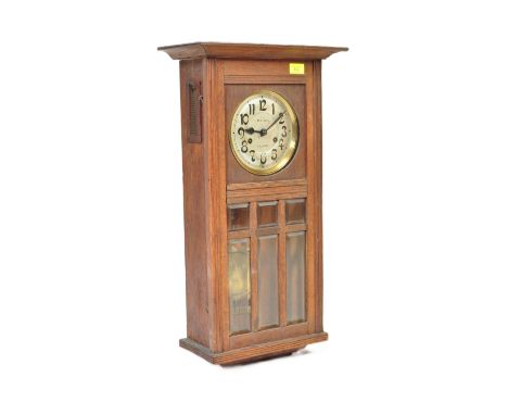 A 1920s French oak cased 8-day wall clock. Silvered dial with arabic numbers to the chapter ring, 8-day movement, the dial ma