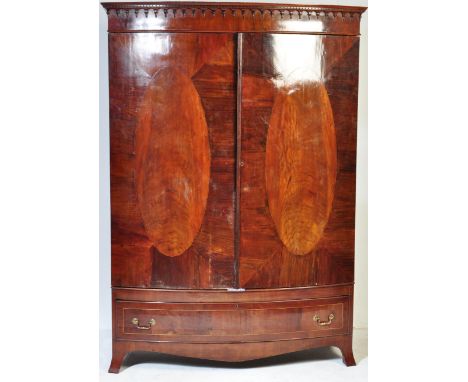 A vintage 19th Century mahogany bow front linen press / wardrobe. Having a flared frieze top, twin veneered sectioned doors, 