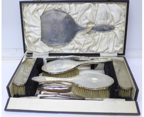 A silver six piece vanity set with a silver handled nail buff, shoe horn and button hook, the case marked William May, Clumbe