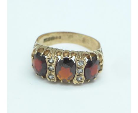 A 9ct gold ring set with three large garnets and white stones, 3.7g, P