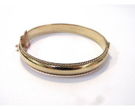 A 9ct gold stiff hinge bangle gadrooned edge with safety chain 